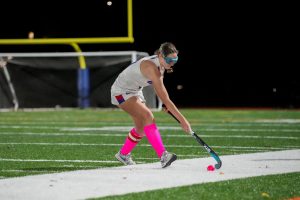 Senior field hockey player Kelly Farrell handles the ball up the sideline. She wears face goggles to protect her face, but still obtained a face injury this season. This is one of the reasons why other players on the Nonnewaug field hockey team opt not to wear them. (Courtesy of Jason Scozzafava)