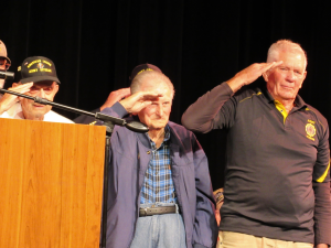 Veteran Dan Gombos, middle, who recently turned 100 years old, salutes as the color guard places the American Flag.