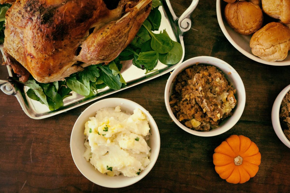 Thanksgiving table filled with the most well known dishes. Some of those dishes being turkey, mashed potatoes, and stuffing, though has the gluttony of a feast overshadowed the most important part: togetherness? (Unsplash photo by Megan Watson)
