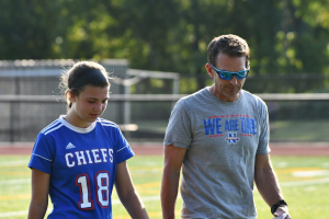 Girls soccer coach Adam Brutting, right, talks to junior Ella Quinn during a game in early September. Brutting just finished his first season coaching the soccer team after 10 years coaching girls basketball.