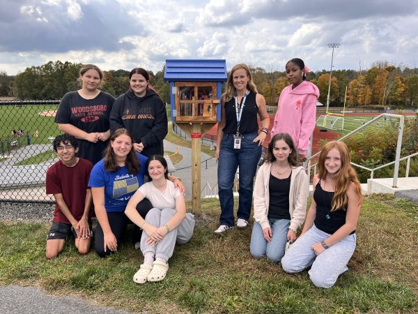 Nonnewaug's Book Club huddles around their newly installed free Book Barn. (Courtesy of the NHS Book Club)