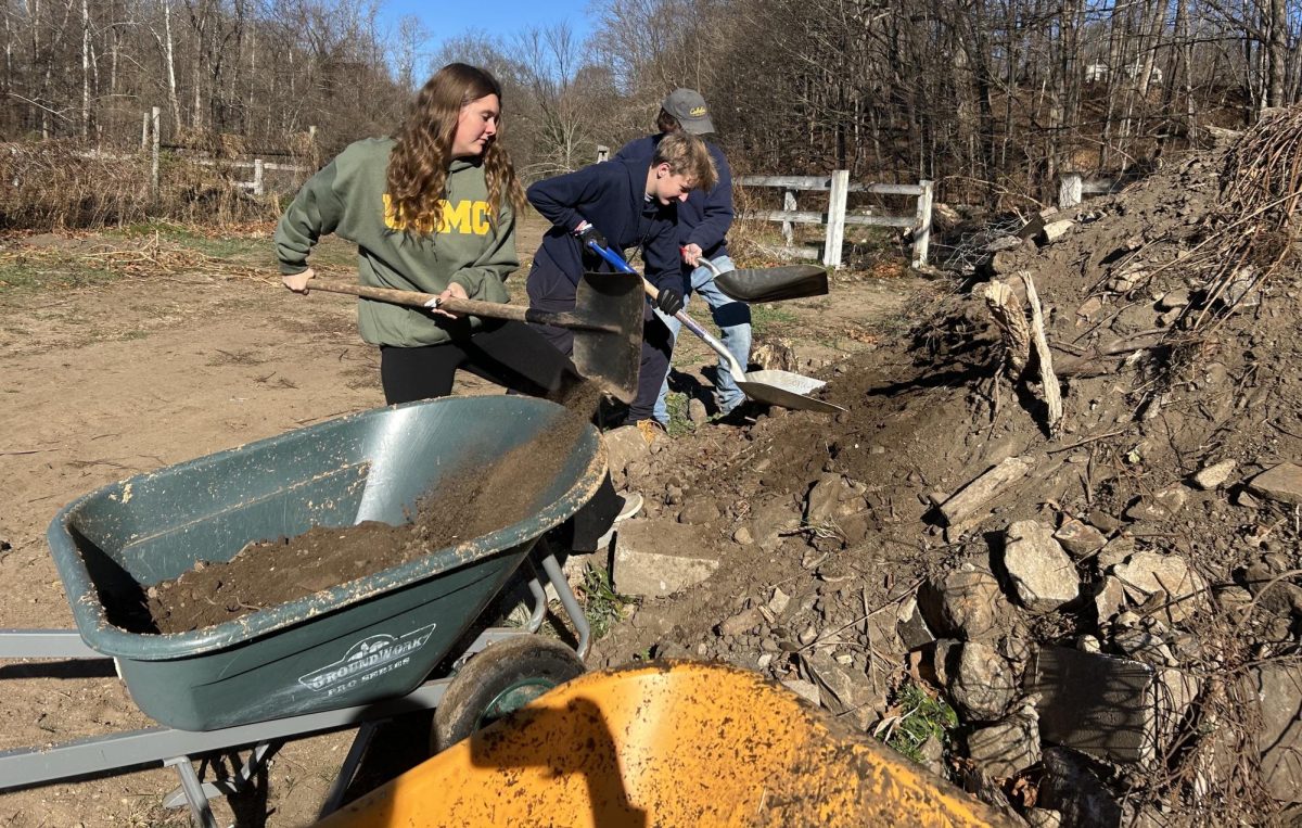 From left, Kyleigh Paige, Billy Calabrese, and Dylan Loring shovel dirt into a wheelbarrow to fill spaces left by old fencing. Students in the ag production classes contributed to new fencing around the ag pastures.