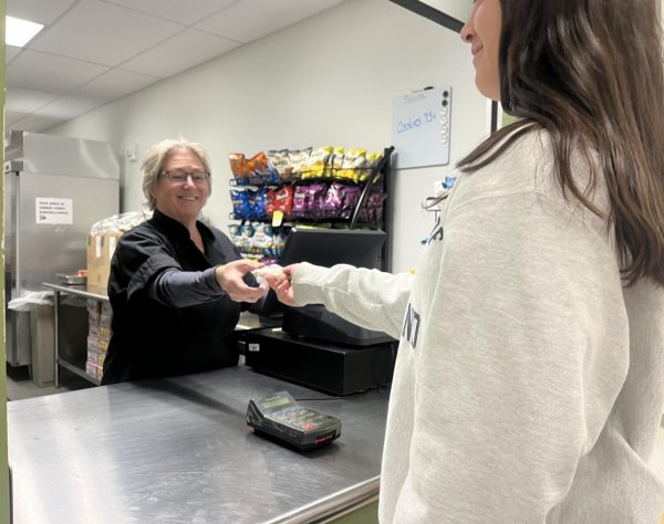 Sophomore Julia Gwiazdoski, right, receives cafeteria cookies from lunch aide Pam Wendt.