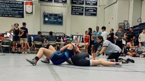 NHS wrestler Indigo Kimball is to the left of her opponent during a wrestling match with her go to move the head lock. Kimball is the only female wrestler on this year's team, though that hasn't detered her from being one of the team's top returners this 2024-2025 season.  Photo Credit: The Kimball Family