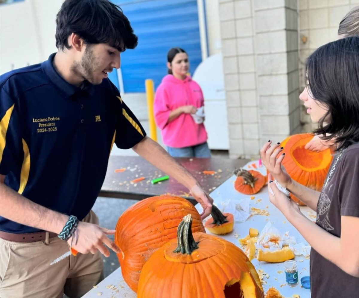 Luciano Pedros takes part in the FFA pumpkin carving event. Moments like these serve as the perfect metaphor for the NHS junior: helping his community as a natural leader.  Photo Credit: The Pedros Family