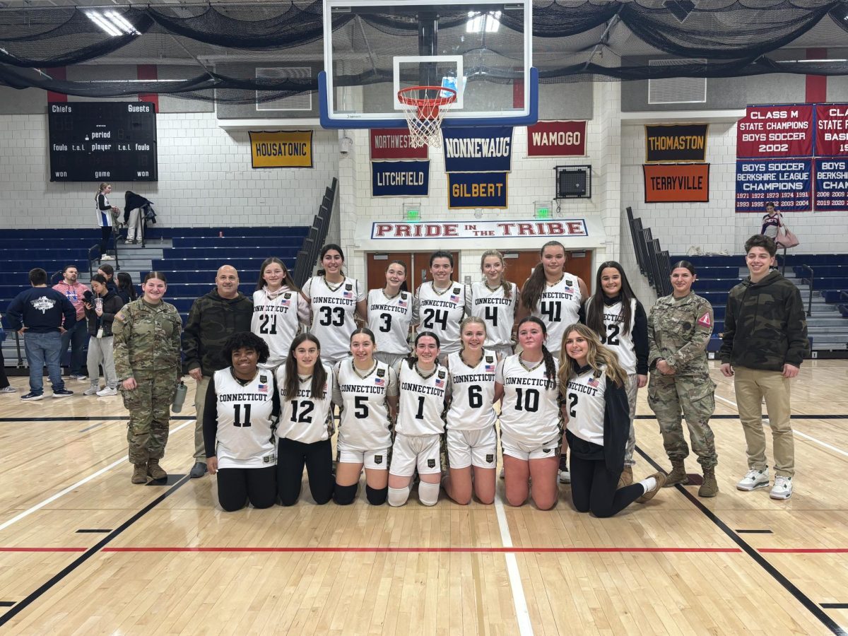 The NHS girls basketball team poses with two military personnel after their victory over Terryville on Jan. 21. This is the first game where the girls wore Connecticut National Guard uniforms. (Courtesy of Abegail Diezel)