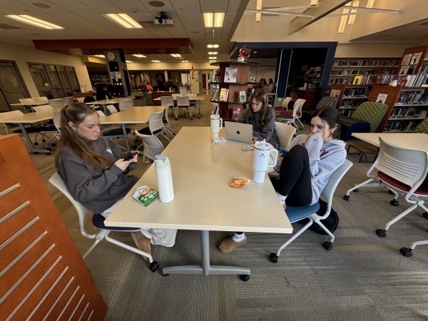 Avery Greaves (left), Hazel Cole, and Regan Lapointe (right), on their phones or other electronic devices in the library during their study hall. NHS students often find it difficult to read for enjoyment during the academic year, though reading, and the critical skills connected to it, are embedded in nearly everything students do at Nonnewaug. 