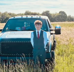 Dylan Bambino posing next to his truck before he goes to last spring's prom. Bambino's truck, a 2011 Ford F350, serves as a symbolic representation of his success as a small business owner. Photo Credit: Kelly Valluzzo