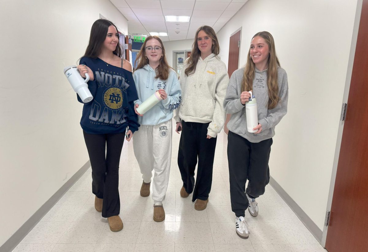 From left, Reagan LaPointe, Savanna Carroll, Hazel Cole and Avery Greaves walk  down the cafeteria hallway, exhibiting the latest trends at Nonnewaug.