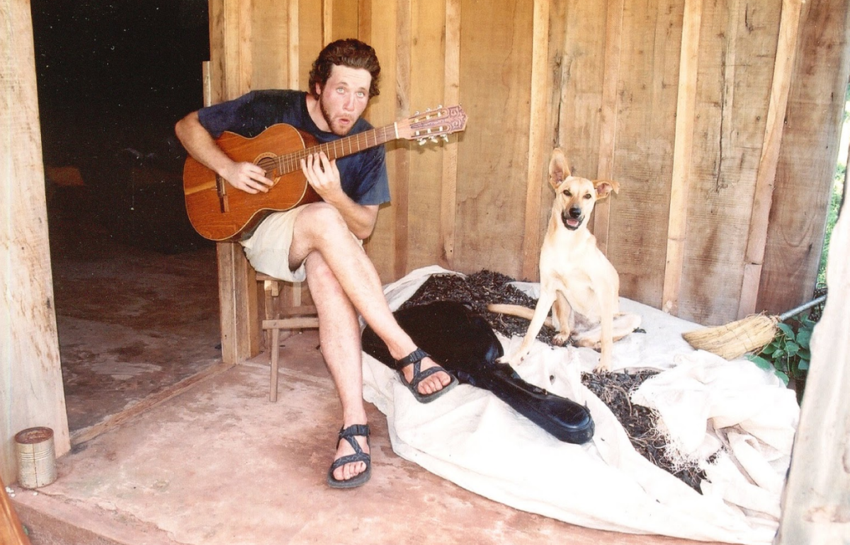 Matthew Greaves plays the guitar with his dog, Lucy, in Paraguay. (Courtesy of Matthew Greaves)