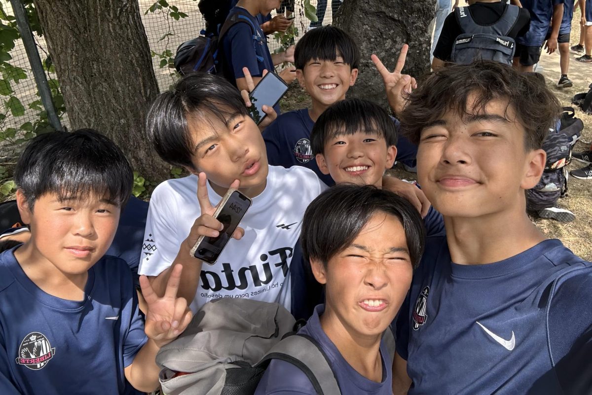 Max Dmitriyev, right, poses with his soccer teammates at practice in Japan. (Courtesy of Max Dmitriyev)