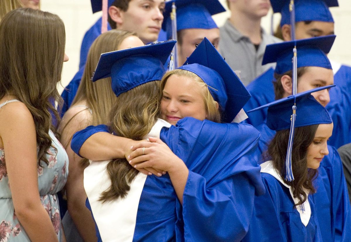 Emma Evans hugs a fellow classmate after the 2018 graduation ceremony. Graduation is an ambivalent time for students, representing a significant change in their lives. (Courtesy of Region 14)
