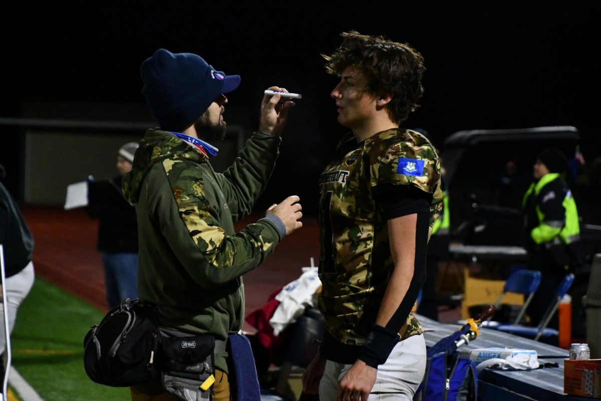 Nonnewaug athletic trainer Sean McGee, left, evaluates Northwest United football player Reed Woerner. Among this past season’s most devastating injuries were absences from wide receiver Derek Chung, who suffered a season-ending injury in November.