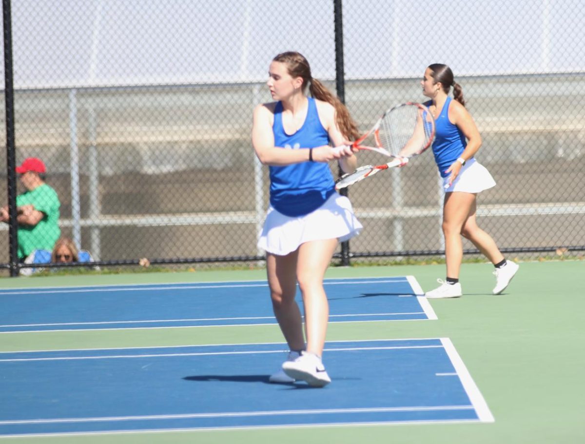 Senior captain Katie Farrell (front) hits a ball on the Nonnewaug tennis courts last season. The team is gearing up for a fun season, starting with new Coach Pezzullo. (Courtesy of Noreen Chung)