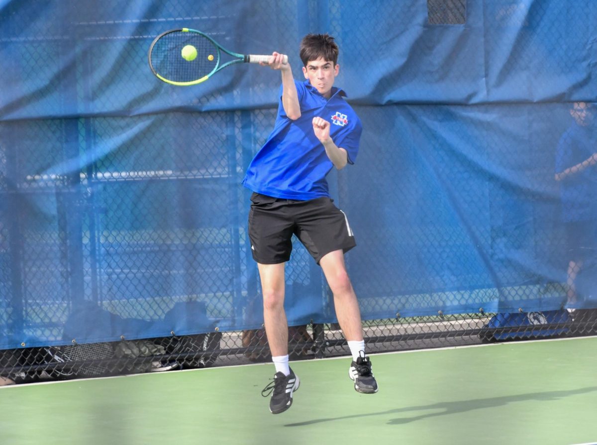 Luke Primini jumps up to hit the ball in a singles match on April 25th against Northwestern. The Chiefs won 5-0. 