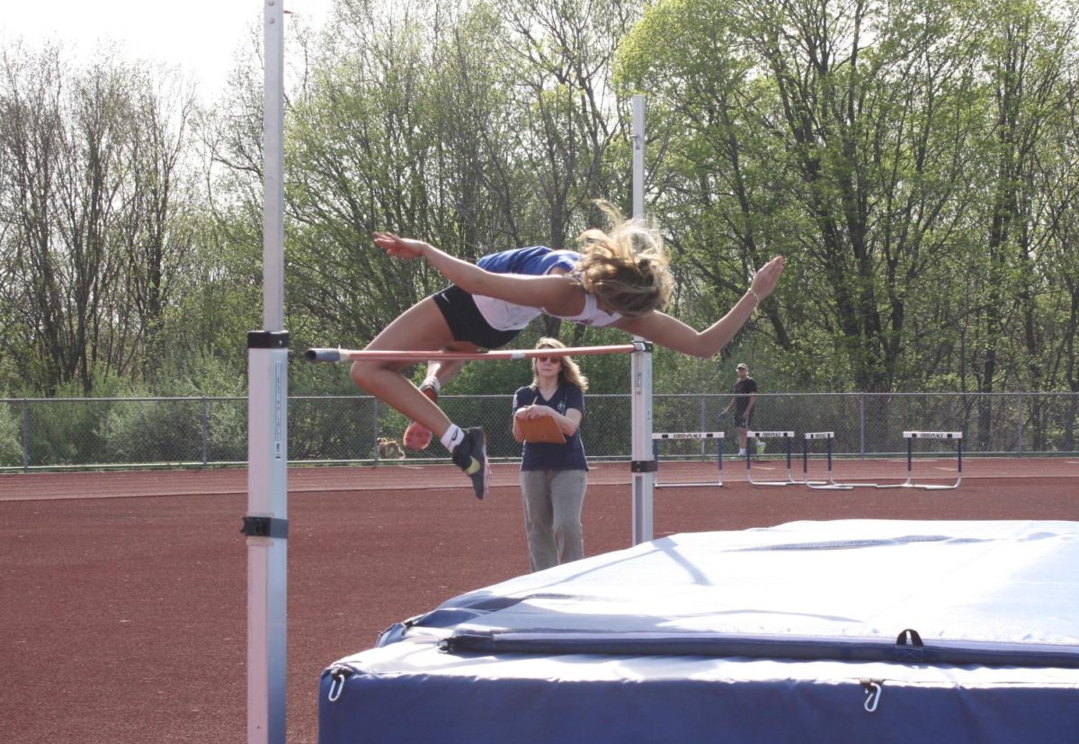 Junior Veronika Nicholas, jumps over the bar during the high jump event at the dual meet on April 29th. The girls team beat Shepaug 119-30. 