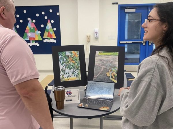 Emily Matozzo, a class of 2024 graduate, presents her MBLE presentation to Toby Denman at the winter MBLE showcase Jan. 24, 2024. Students had the opportunity to share their passions and interest to NHS faculty, however, for the class of 2027 and beyond, students no longer have to participate in the MBLE. (Courtesy of Nonnewaug High School/Instagram)