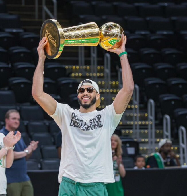 The Celtics' Jayson Tatum holds the Larry O'Brien NBA championship trophy after leading Boston to the title last season. (Courtesy of the Office of the Governor of Massachusetts/Wikimedia Commons)
