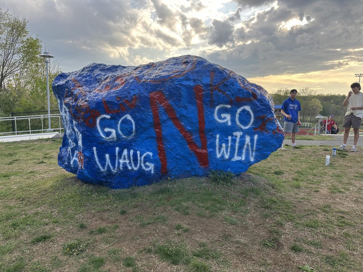 “The rock” stands completely painted looking over the athletic fields. Senior athletes celebrated the end of their high school careers at the beginning of May. (Courtesy of Ellie McDonald)