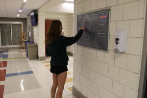 Haley Lavelle, a freshman at Nonnewaug High School, trying to find her class using the map in the hallway. She uses room numbers that the map shows to match her schedule to help navigate around the school.
