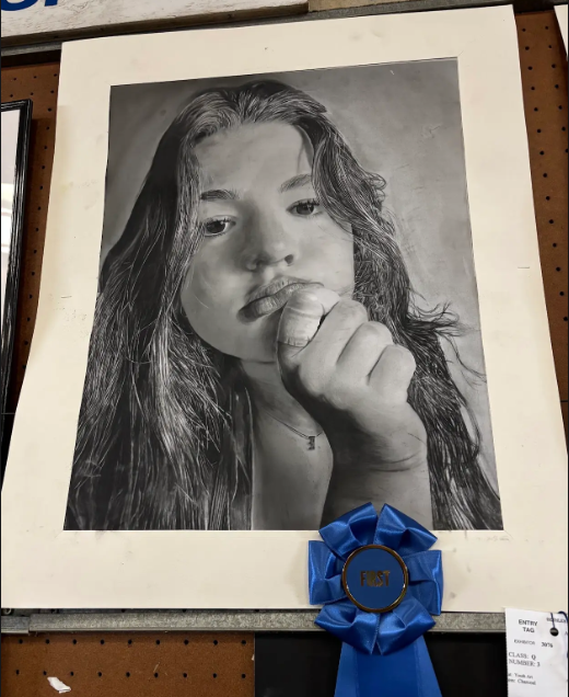 Ella Quinn showcases her self portrait drawing that got first place at the fair. Pieces like this create a strong reputation for Nonnewaug's art program. 