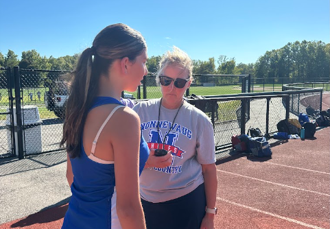 Danielle Carroccio discussing times with one of her runners. Carroccio realizes that developing a good coach- athlete relationship is integral to a strong team culture. This semester serves as Carroccio's first fall as coach and math department faculty at NHS. 
