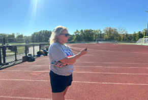 Danielle Carroccio, the new coach for nonnewaug's cross country team, times her runners during a Cross Country practice. 