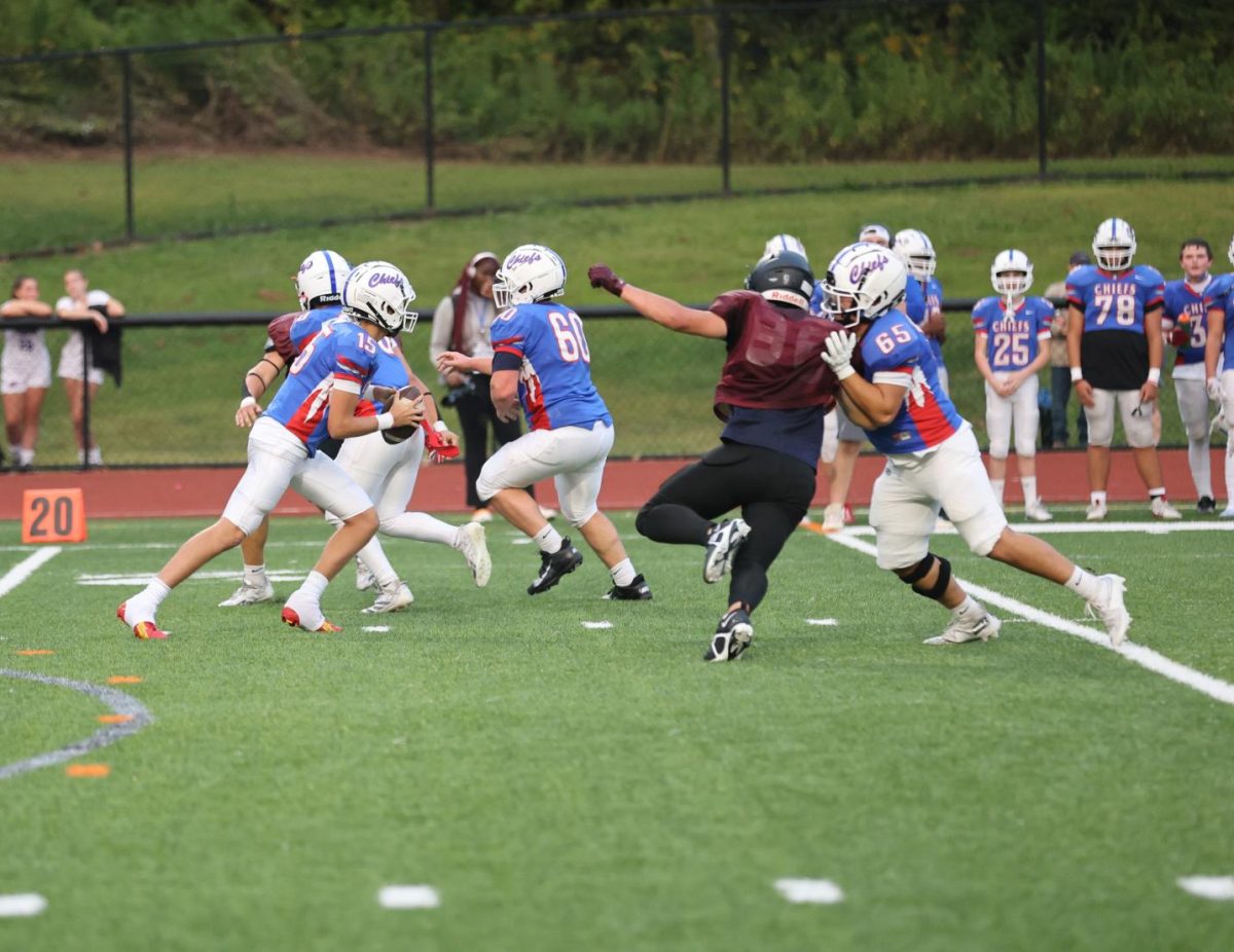 Jonathan Cheung (65) performs a block in Nonnewaug's scrimmage vs Torrington. Cheung is one of the many varsity seniors who honed skills at the JV level. (Photo courtesy of Noreen Chung)
