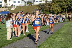 Grace Rubacha followed by Valerie Chandler race to the finish line with fellow Chiefs cheering them on at the Nonnewaug Cross Country Invitational Oct. 3.