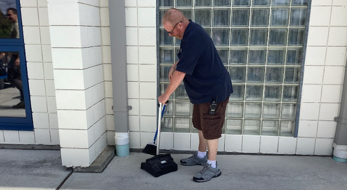 Nonnewaug custodian Clayton Hilpertshauser cleans food outside during lunch. He is allergic to bees, and there have been many on Nonnewaug's outdoor lunch patio. 