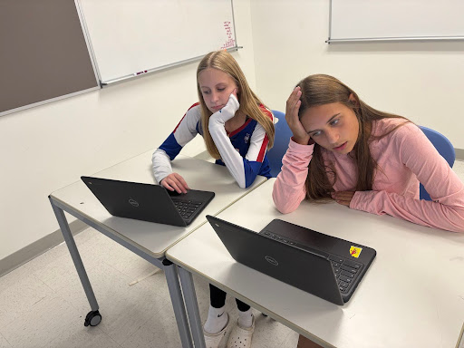Freshmen Sam Savulak and Hope Davis frown at their schedules. Many other students go through the same struggle. 