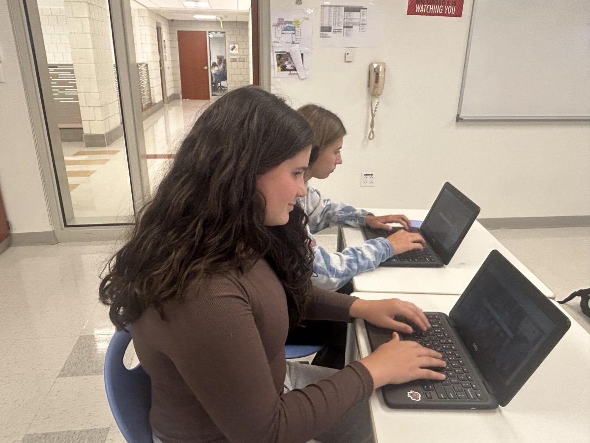 Freshmen Julianna Fazzino and Maddie Holtman work on computers during class.