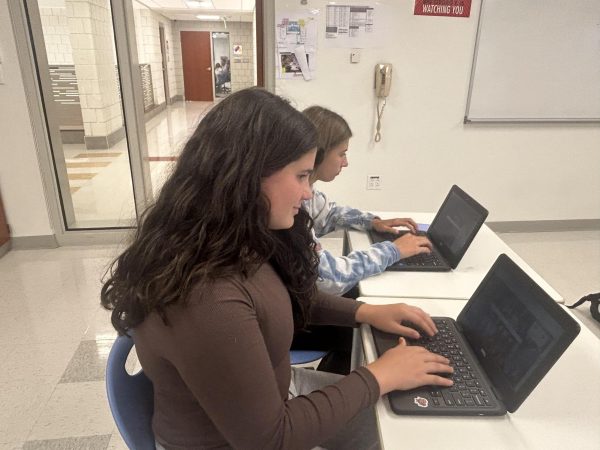 Freshmen Julianna Fazzino and Maddie Holtman work on computers during class.