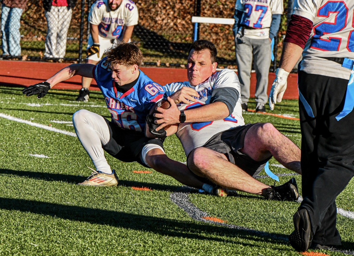 Senior Brycen Gagne and teacher Joseph LaFlamme fight over the ball on Nov. 24 during the annual Thanksgiving Cornbowl and Powderpuff NHS games.
