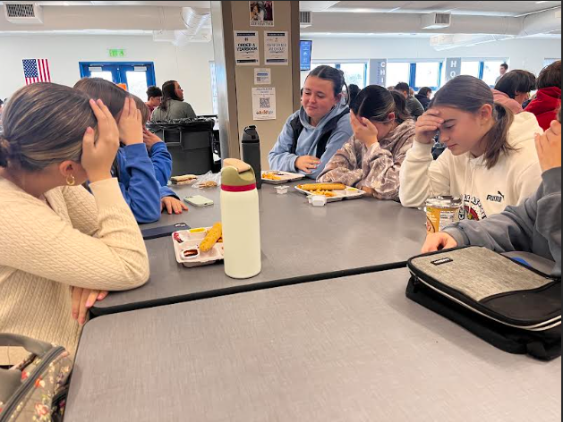 A group of stressed out girl in the cafe just trying to enjoy their food. These students say they are in need of a quieter place to eat. 