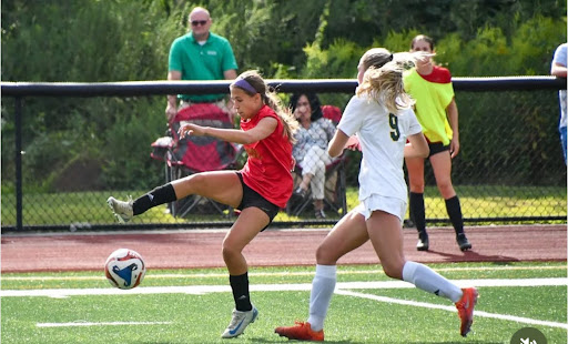 Maddie Holtman, left, traps the ball during a game. She participates on the soccer team and will be joining the indoor track team.