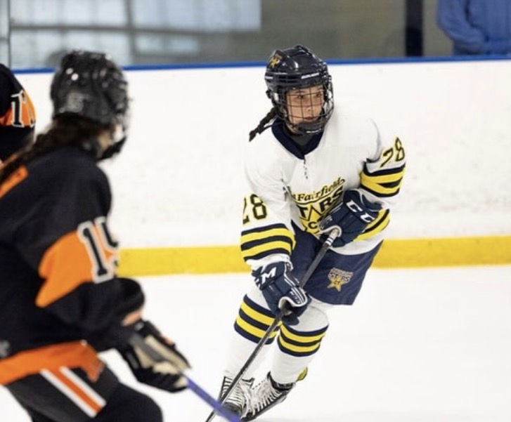 Toon takes the puck up the ice durring a game with her Mid Fairfield team. Toon leads her team to victory with her vigorous play and undeniable shot which gets her noticed by many prestigious high schools. (Courtesy of Charlottle Toon)