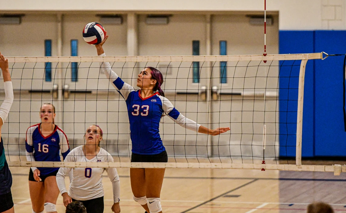  From left to right Macey Chimmel, Jordan Kovach and Lana Zupnick. Zupnick jumps to tip the ball to the other side. Zupnick helped to guide this year's team to historic levels as NHS volleyball climbed to the state semifinals in November. 
