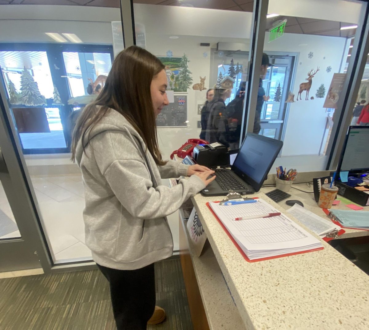 Elliana Obolewicz signs into the main office. This is what all students have to do when they come into school late. During the months of January and February more students find themselves signing into the office due late arrivals.  