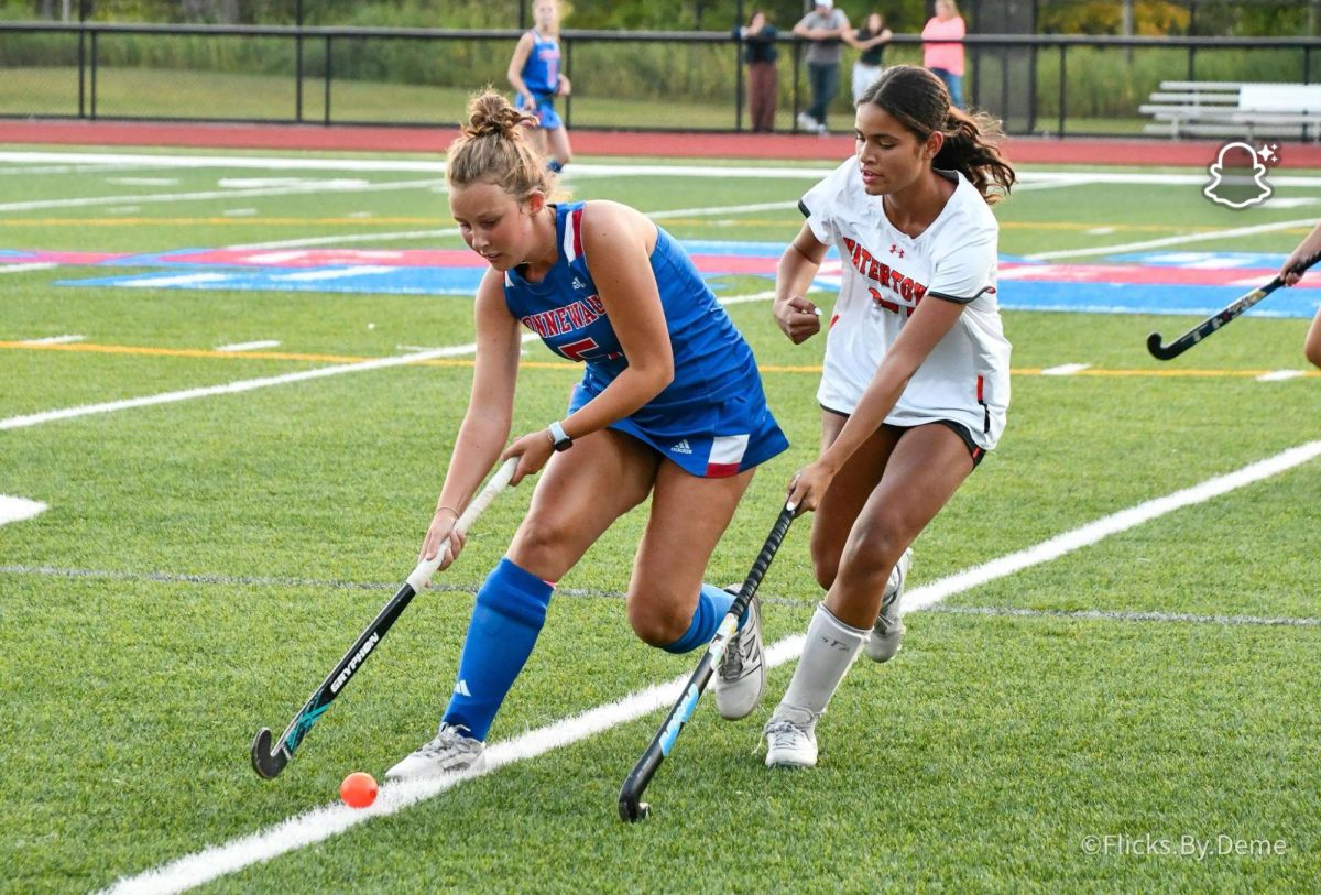 Heron maintains control of the ball while under pressure from a defender in a field hockey game against Watertown. (Courtesy of Jadyn Heron).