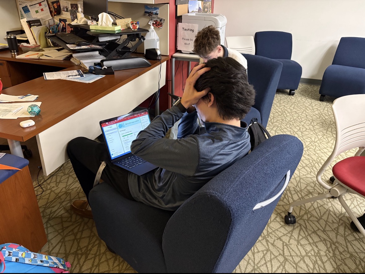 Matthew Clifford Sits at college counselor Kathy Greens desk to work on finishing his college applications. Clifford is stressed about the amount of work and waiting that comes along with the college process.