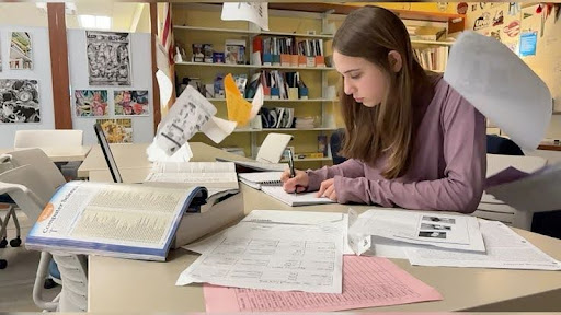 Freshman Sam Savulak writes in her notebook as she studies for all upcoming quizzes before completing other due assignments. She has an intense workload and is struggling with academic burnout. 