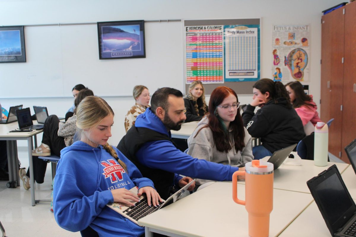 From left, junior Grace Hart, Kyle Tehan, junior Savanna Carroll. Tehan helping the two work on a health project and students have long appreciated Tehan's clear communication skills.