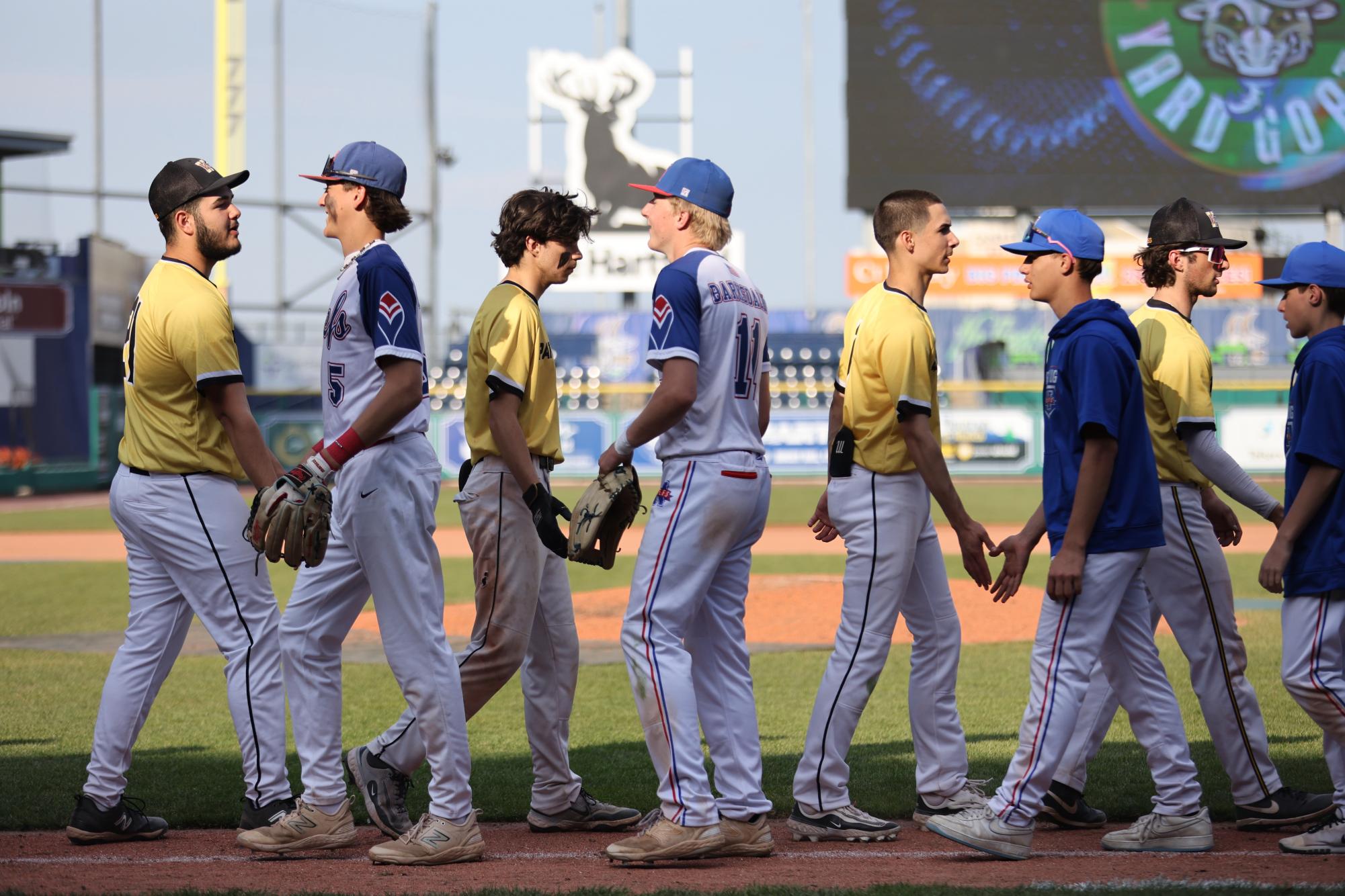 The Nonnewaug Baseball team shakes hands with their opponent at their almost annual appearance at the Dunkin Park in 2025. Nonnewaug Baseball will be one of many sports teams affected by a potential change in league affiliation. (Photo Credit: Noreen Chung)