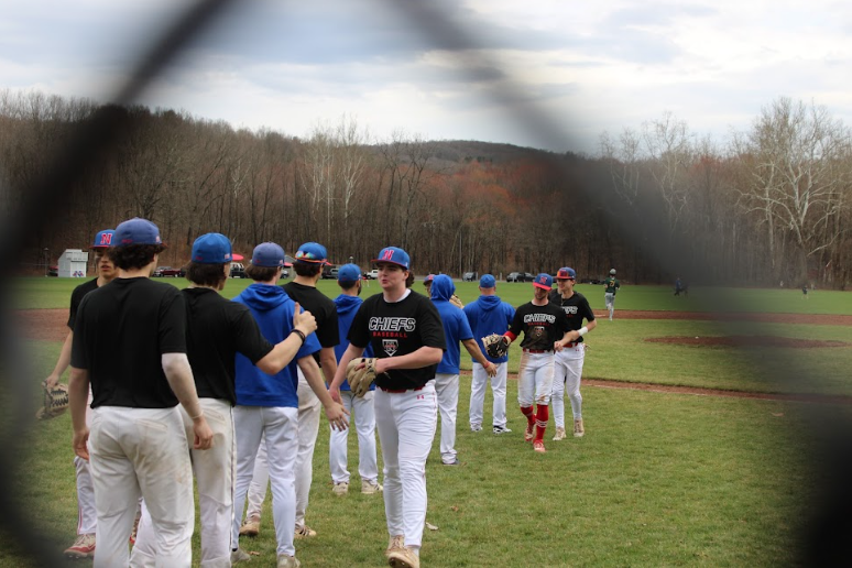 Nonnewaug baseball team members high-five each other after coming off the field during the Nonnewaug vs Holy Cross scrimmage, April 1st, 2026. They played 7 innings resulting in a tie, 4-4.