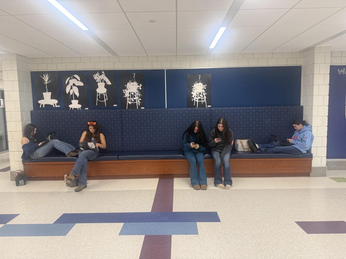 From left, Freshman Cadence Sweeney and Harriet Balius get their work done while having a quite comfy area to sit. In the middle, from left, Annalie Taylor and Sam DeNovellis finish chatting before going back to class after lunch. On the far right Addison Tournas also tries to get work done while listening to music to focus instead of in a classroom. Many students at Nonnewaug use the bench in many different ways.