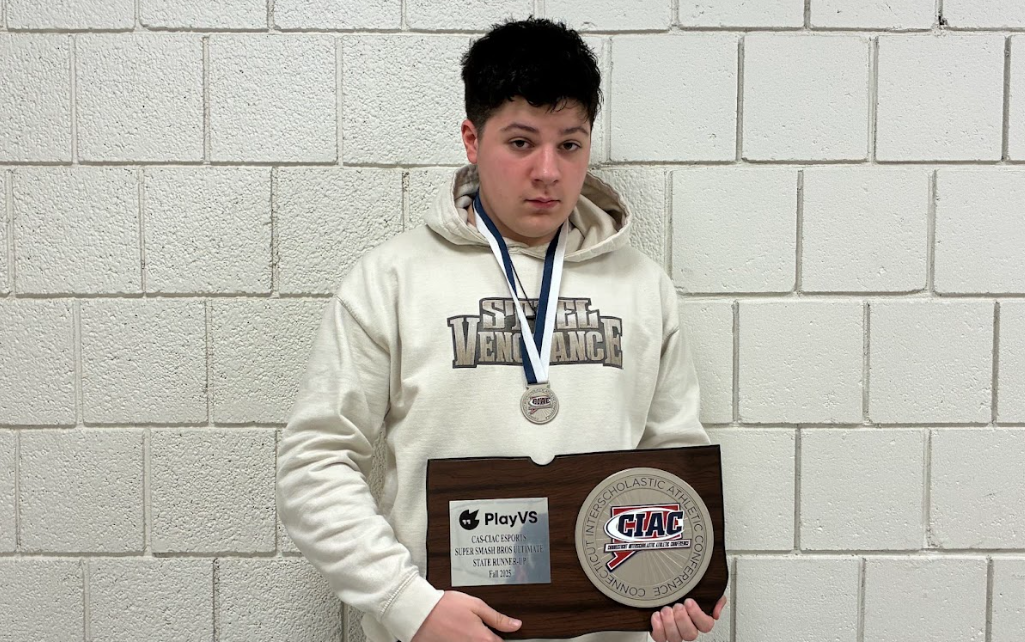 NHS ESports member Dante DiGiovanni displays last fall's runner-up trophy. DiGiovanni is one of just many members who compete for coach and faculty member Katie Blake. (Photo Credit - Contributed)