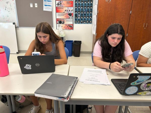 From left, Maddie Holtman and Juliana Fazzino play on their phones during study hall.